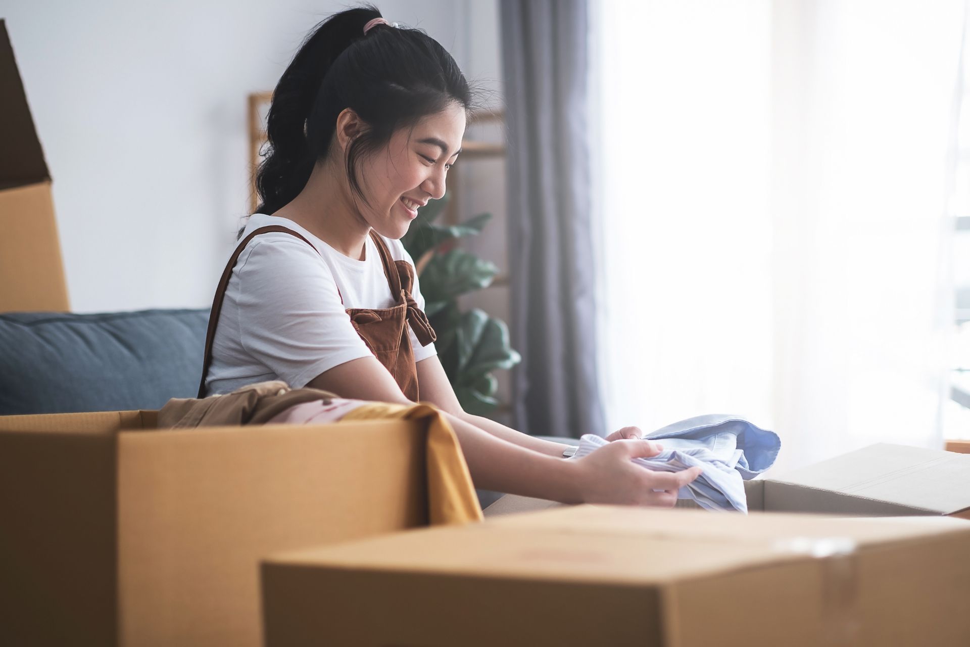 Image of a young woman unpacking boxes in a new home