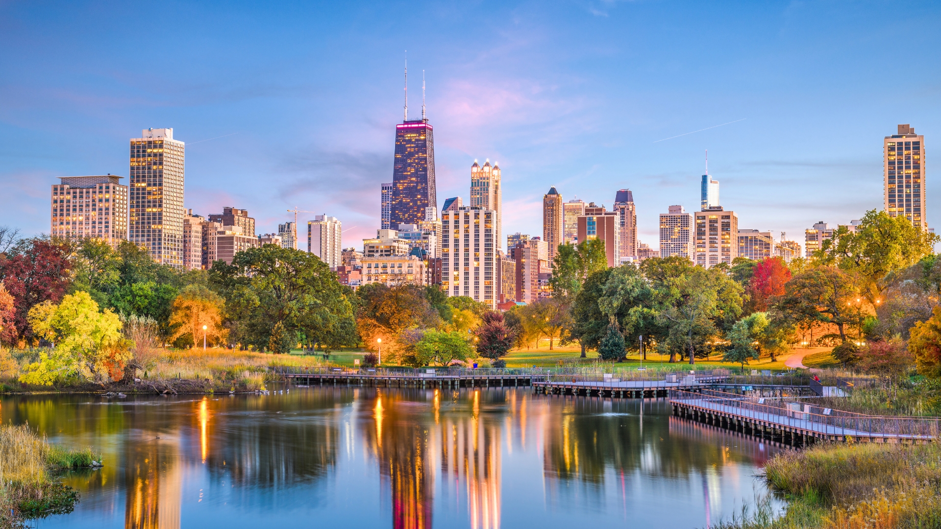 An image of Lincoln Park at sundown with the Chicago skyline illuminating