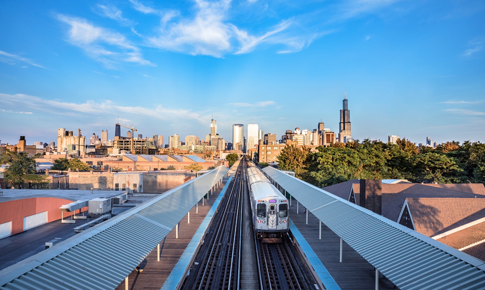 An image of a Chicago public train traveling into downtown Chicago with the Chicago skyline behind it