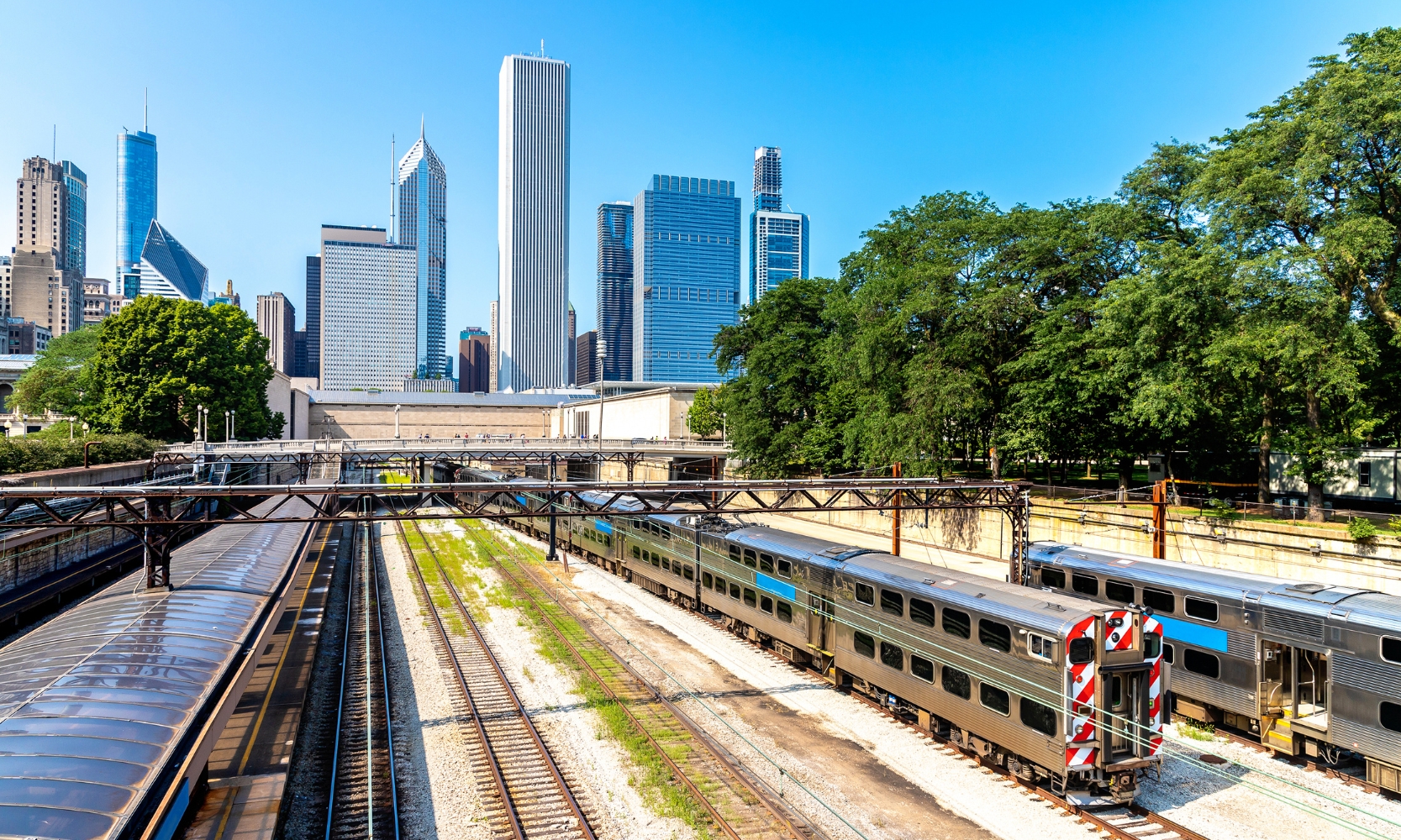 An image of a Chicago public train traveling into the city with the Chicago skyline in front of it