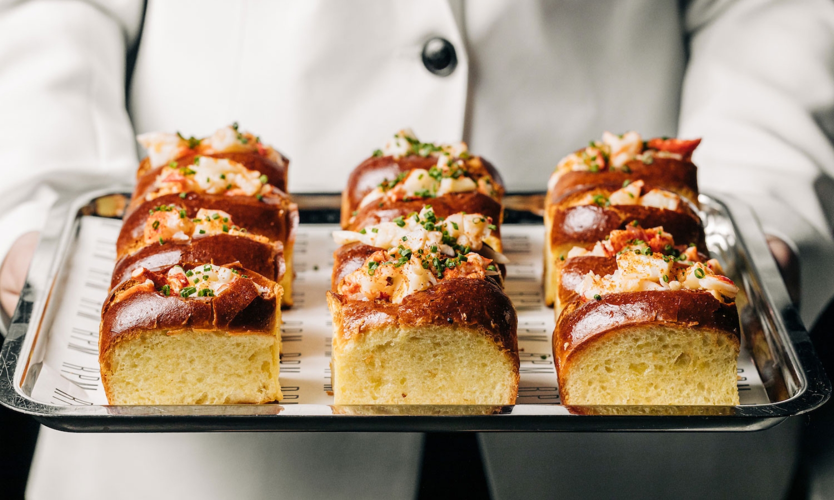 A closeup image of mini lobster rolls being served by a chef at RPM Seafood in River North, Chicago