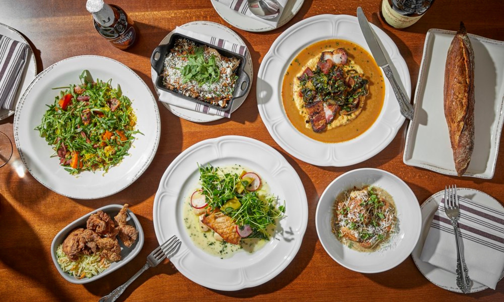 Top view image of a dinner spread with multiple dishes at Dear Margaret in Lakeview, Chicago