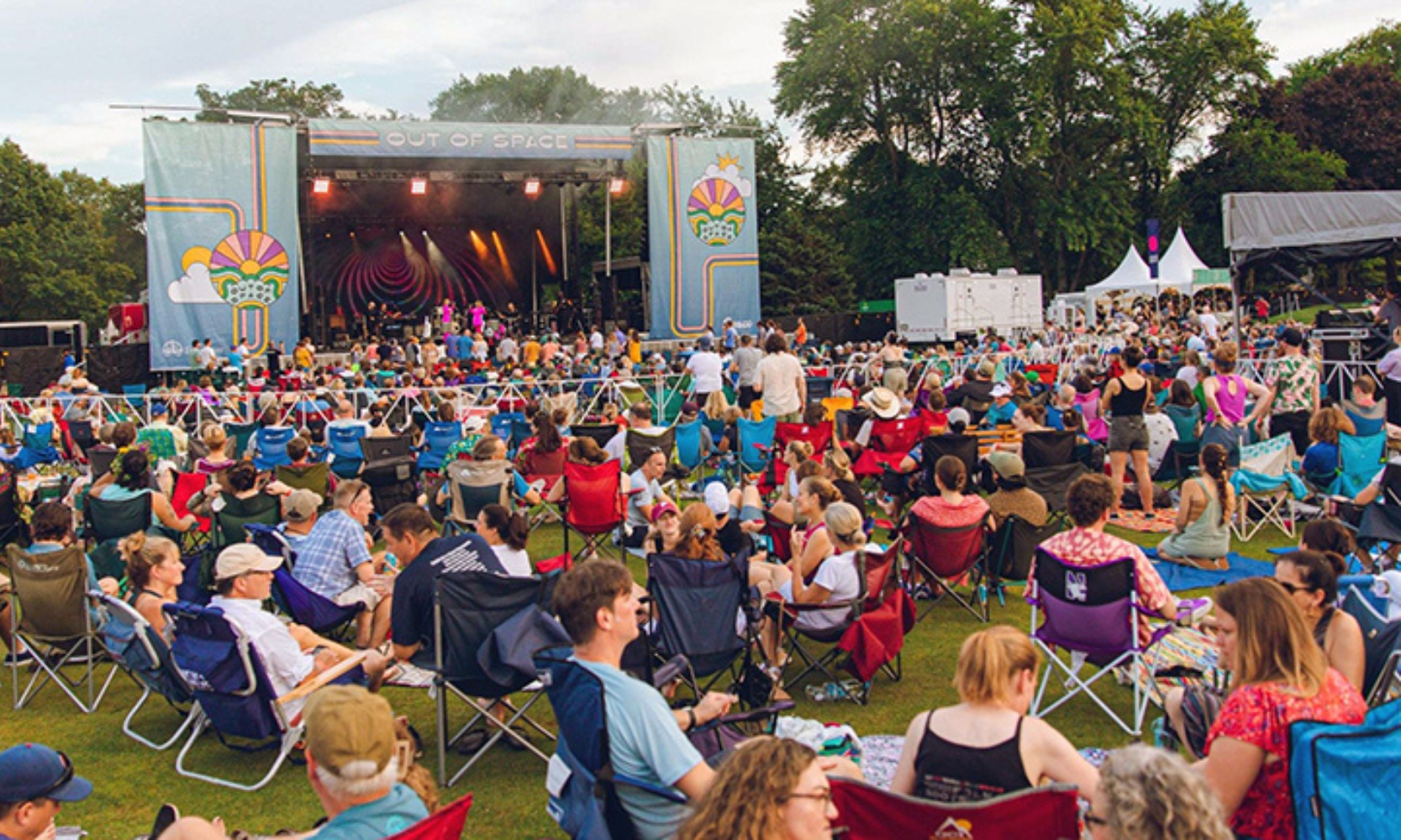 Image of a large group of people sitting in front of an outdoor stage at downtown Evanston's Summer Sounds