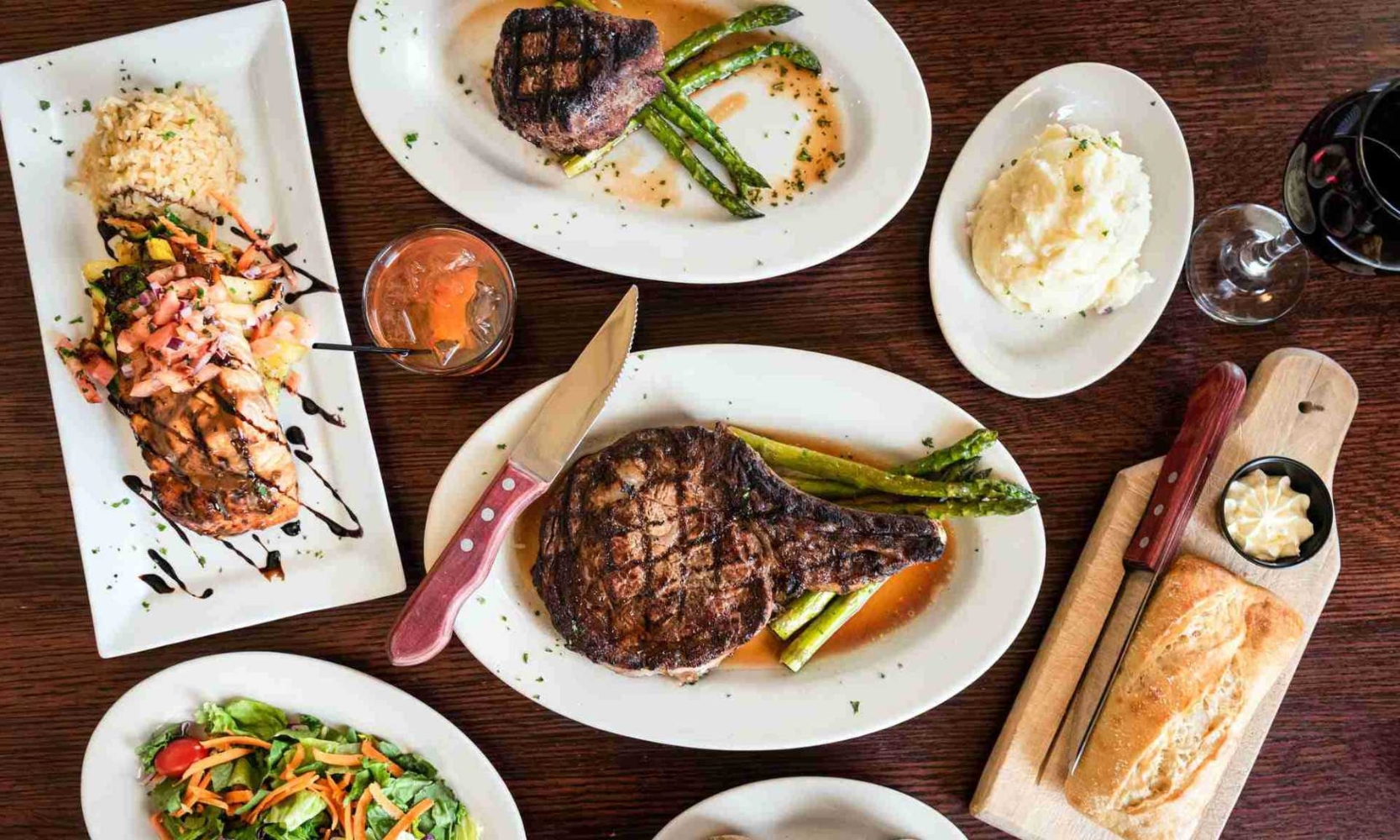 Top view image of multiple steak and chops entrees with side dishes at Jameson's Charhouse in Arlington Heights, IL