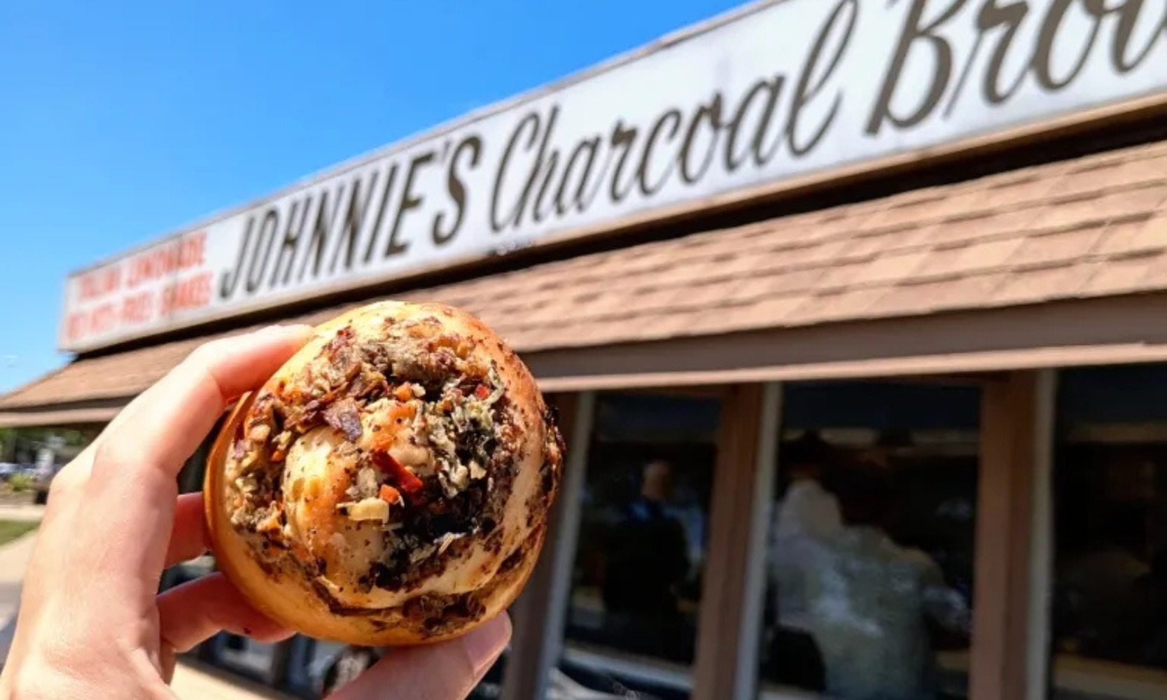 Exterior image of Johnnie's Beef in Arlington Heights, IL, with a hand holding a breakfast burrito