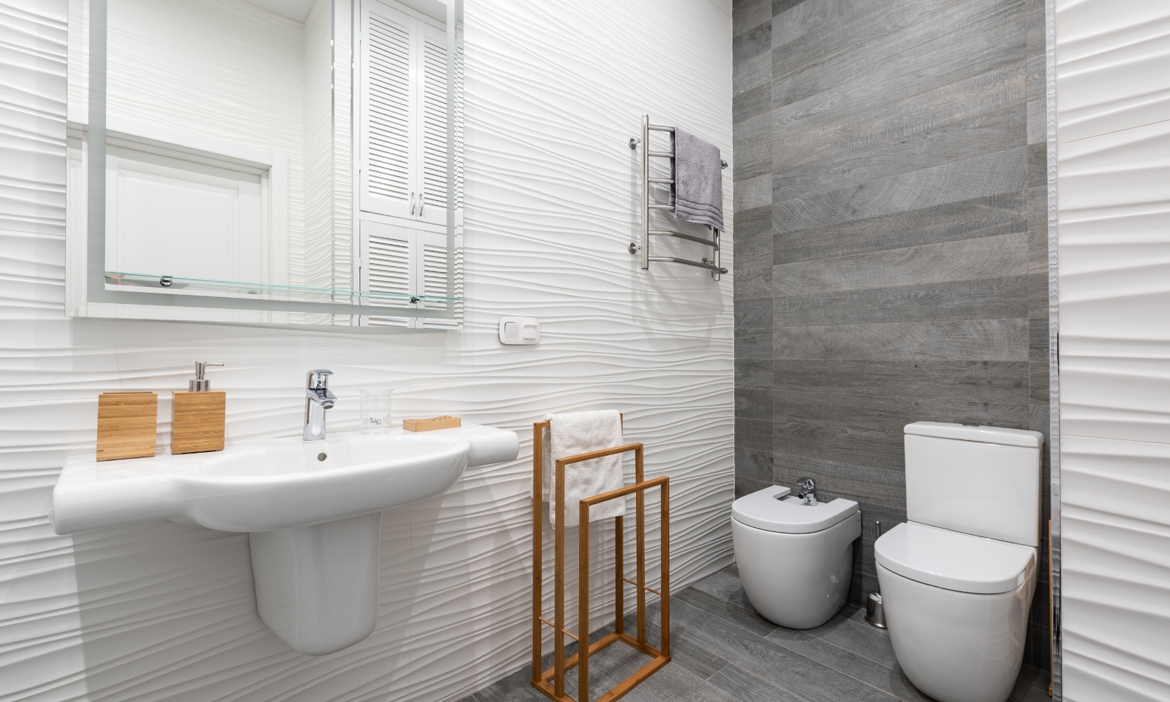 Image of a small bathroom with white wavy textured and dark gray tile walls