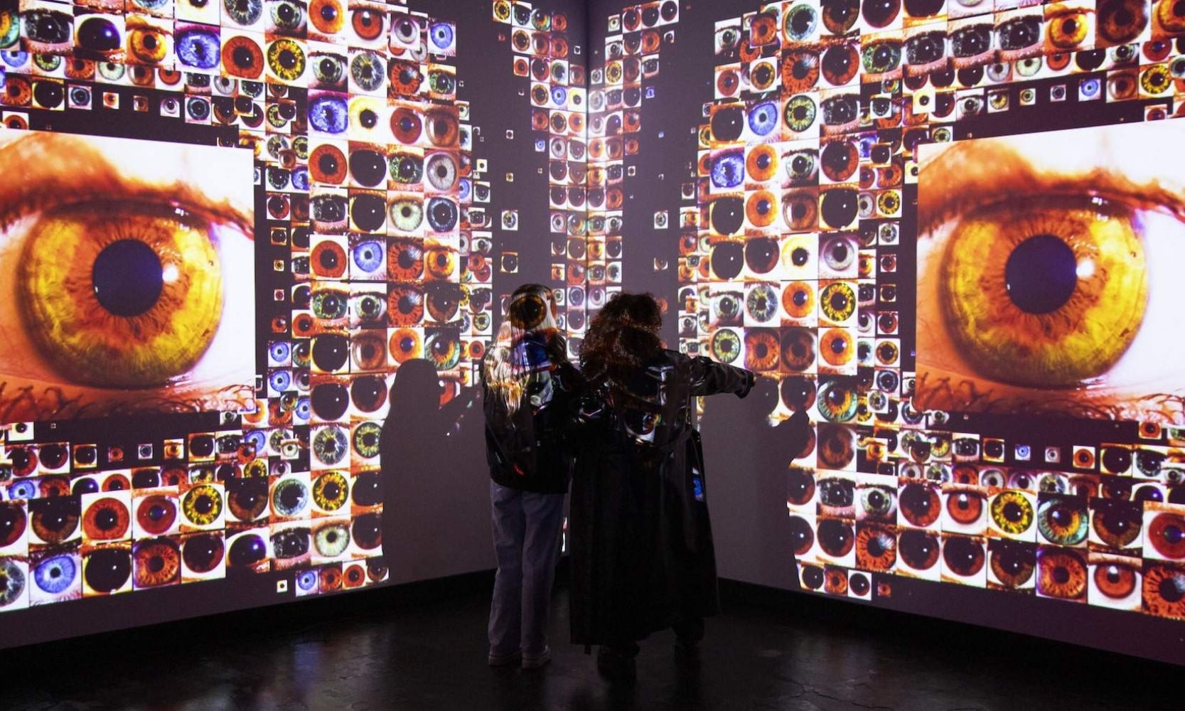 Image of the Iris immersive art installation with two people at the WNDR Chicago museum