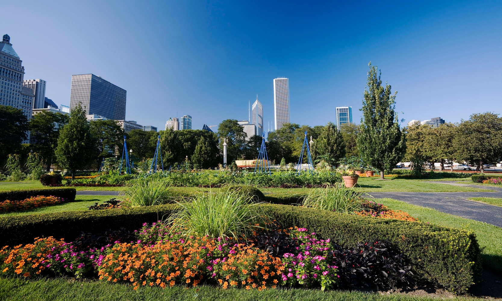 Daytime photo of Grant Park in Chicago with flowers, greenery, walkways, and skyscrapers