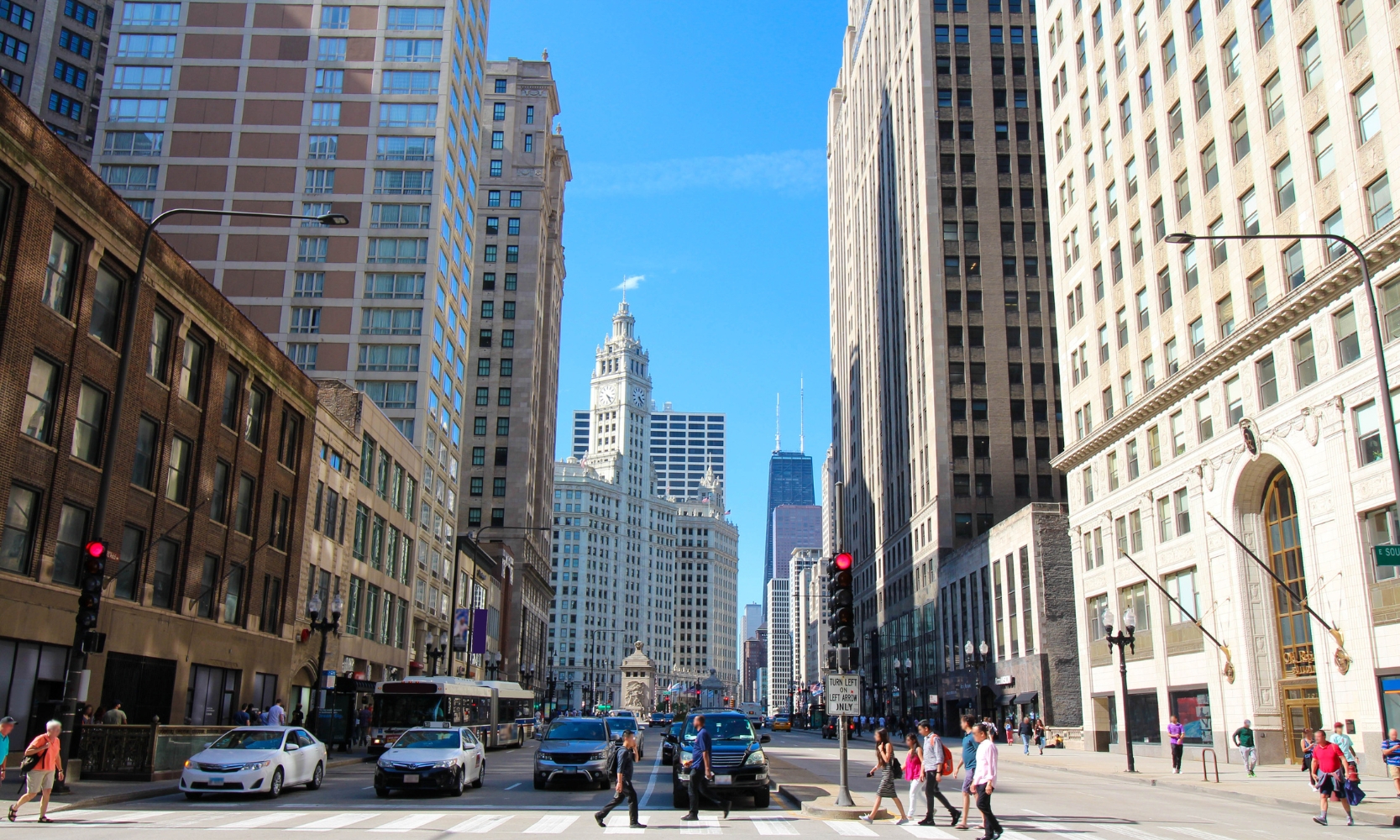 Daytime image of Chicago's Magnificent Mile with people crossing the street and cars at a stoplight