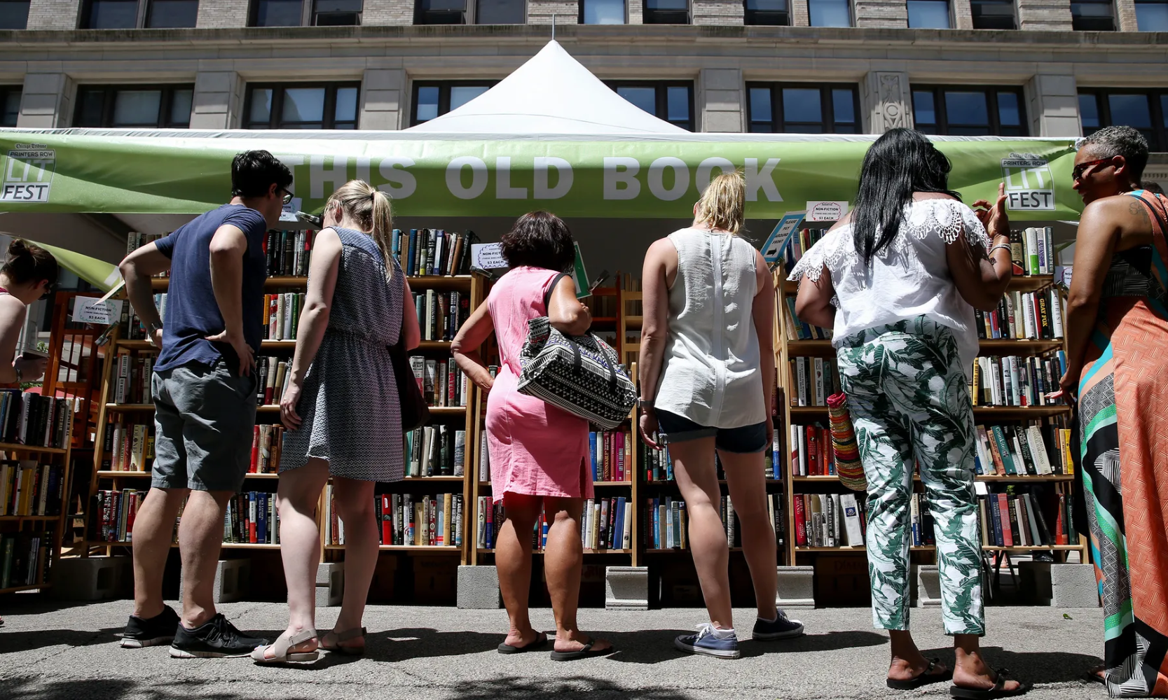 Rear view image of people browsing through books at Printers Row Lit Fest vendor in Chicago