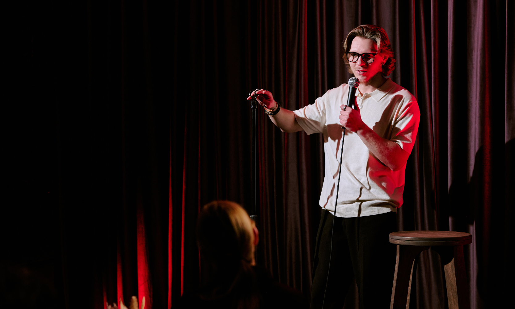 Image of a standup comedian performing with people watching