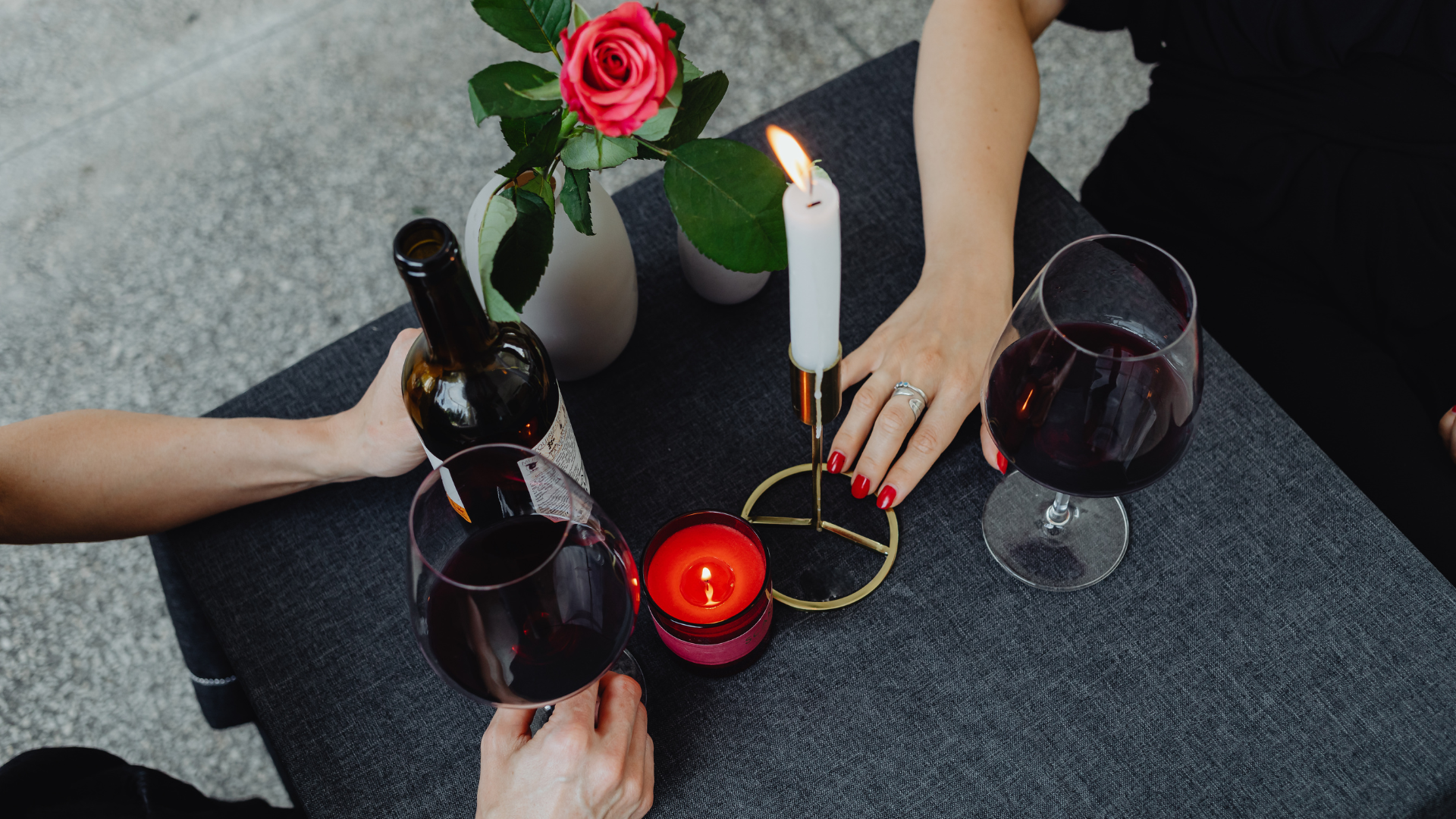 Closeup image of a couple having a romantic winter with their hands and wine