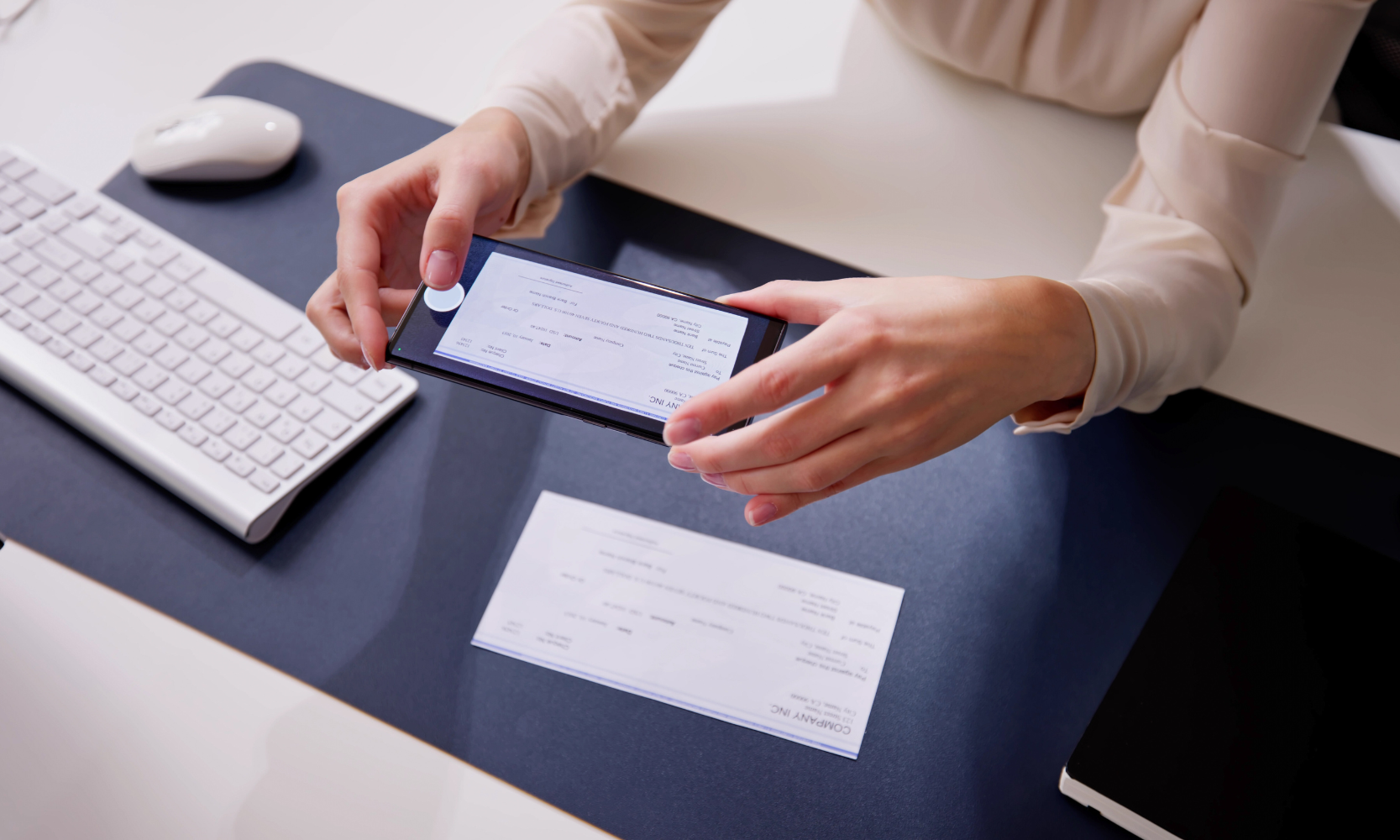 Closeup image of someone's hands depositing a check on a phone