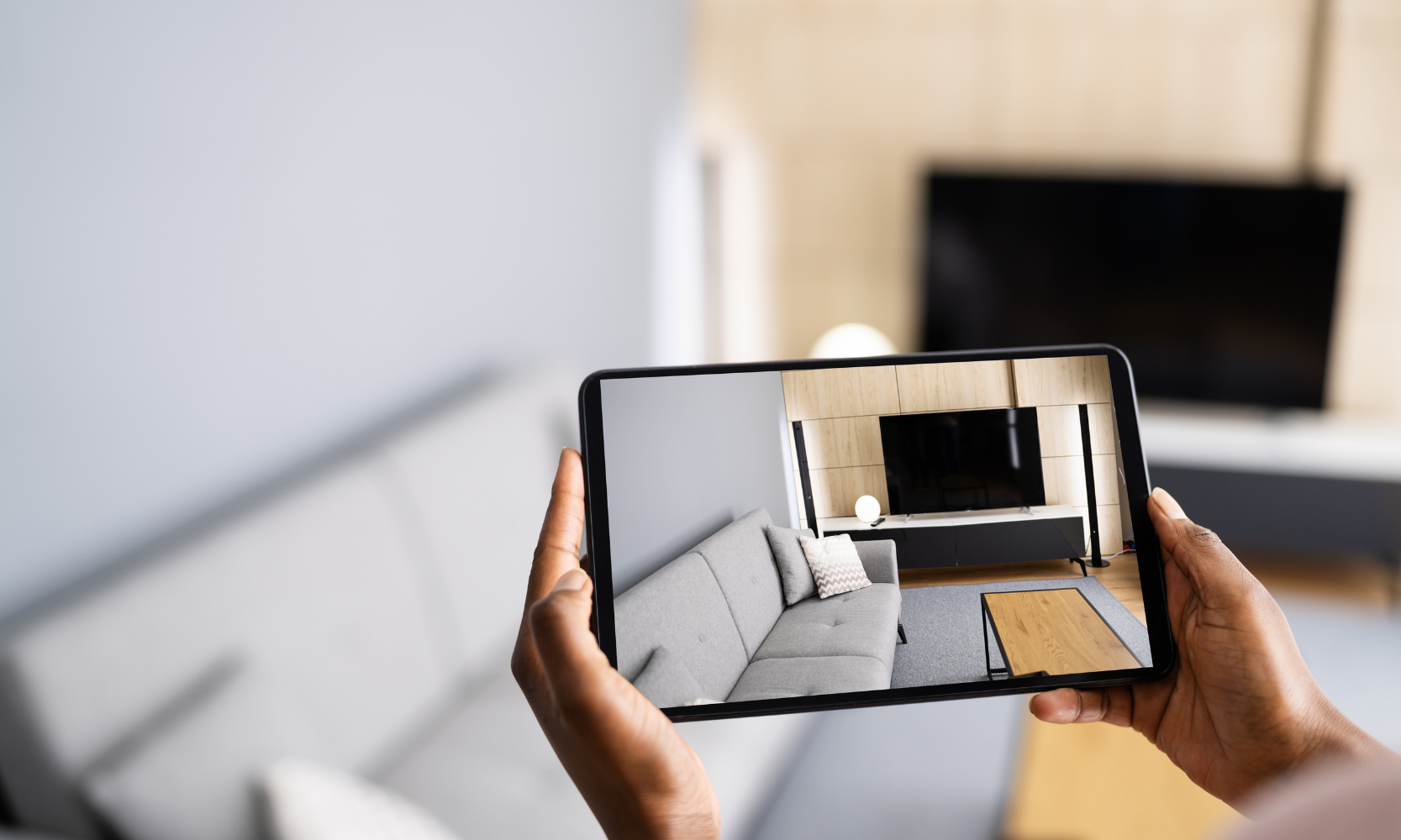 Close-up image of a person's hands holding a tablet and taking photos while on an apartment tour