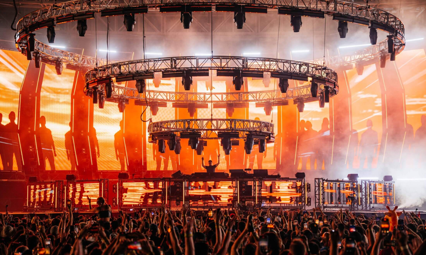 Rear-view image of a crowd dancing at a large stage at the ARC Festival in Chicago at night