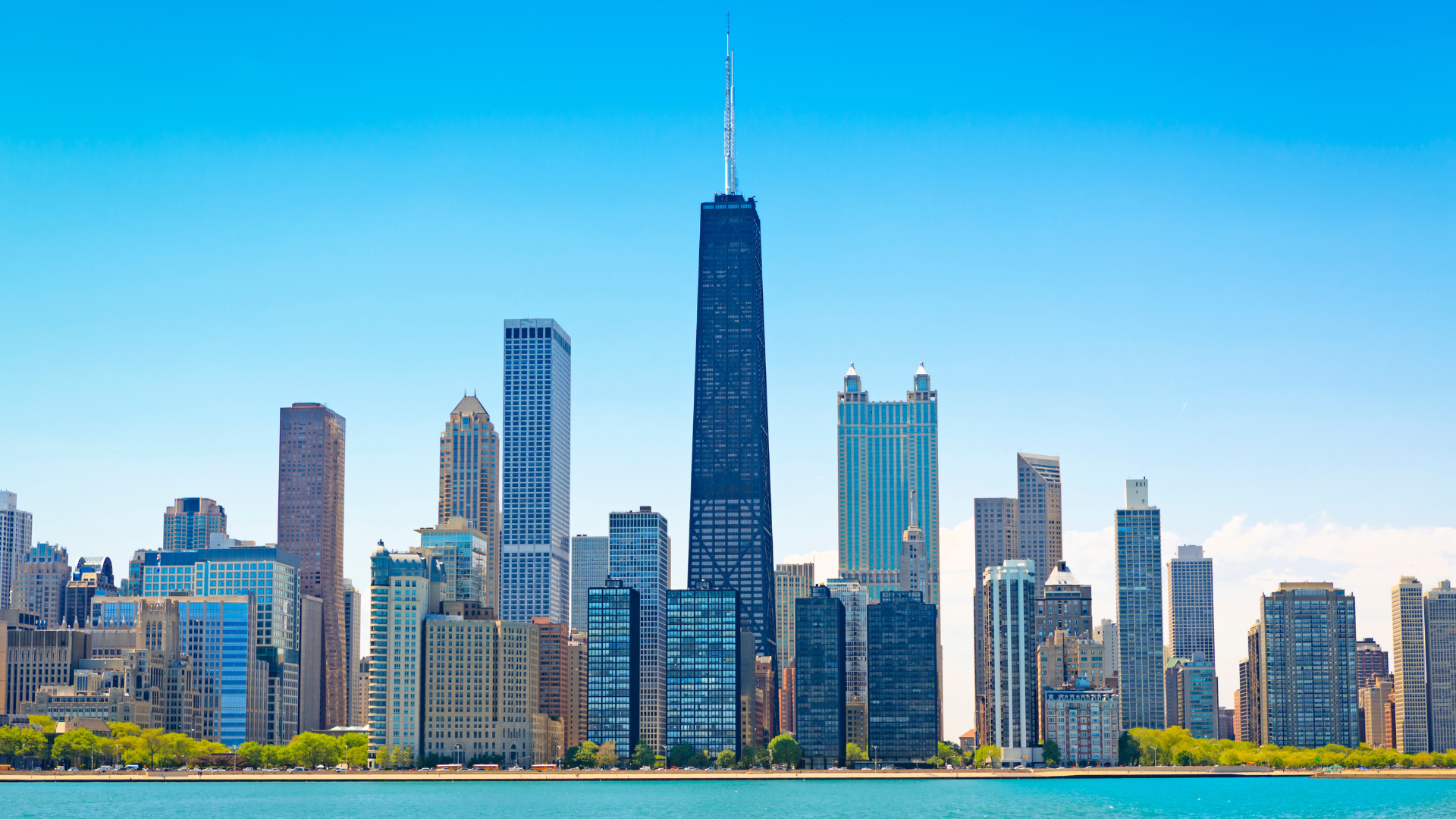 Image of the Chicago skyline behind the Lake Michigan shoreline during the day