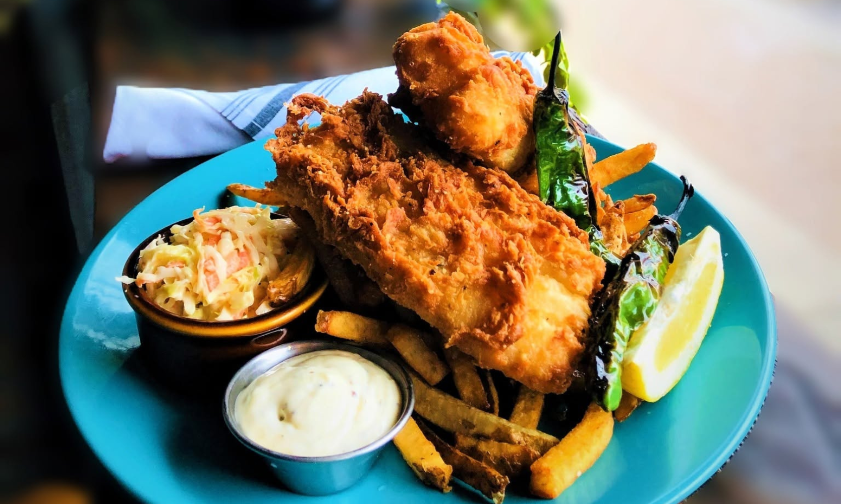 Close-up image of the fried fish entree at Allegory on a blue plate