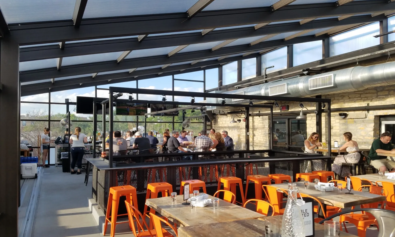 Interior image of the Empire Burgers + Brew retractable rooftop dining area with customers eating